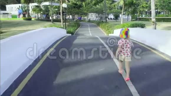 小女孩走在热带人行道上视频的预览图