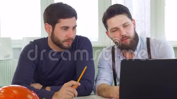 两位建筑师看着笔记本电脑屏幕视频的预览图