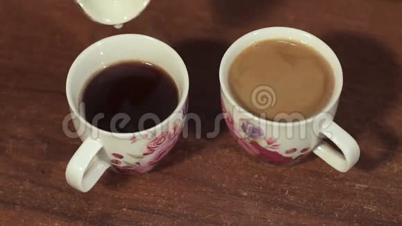 特写牛奶倒入两杯咖啡杯视频的预览图