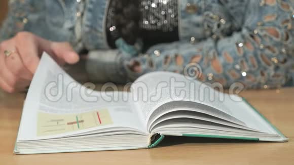 不知名的学生女孩在读一本书特写视频的预览图