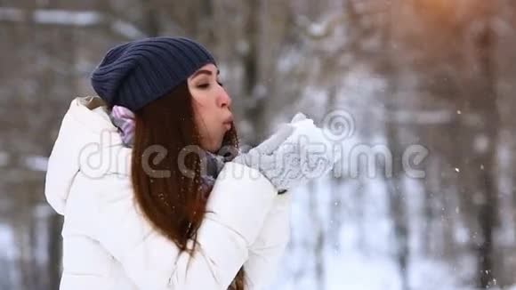 冬天的女孩吹雪美丽快乐的青少年模特女孩在冬季公园玩得很开心美丽的年轻女子在户外笑恩杰视频的预览图