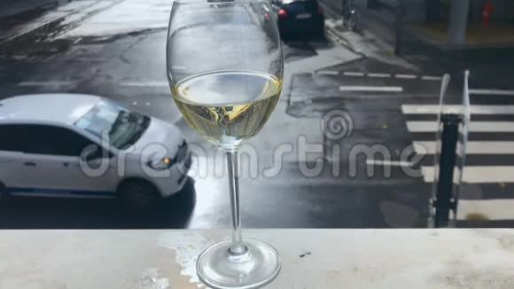 城市街头背景的带白葡萄酒的玻璃杯视频的预览图