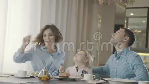 现代家庭带着一个小孩在家庭餐厅吃甜点视频的预览图