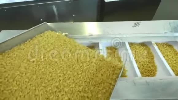 面食工厂和面食生产阶段在现代食品生产中关闭从机器单元溢出的干通心粉视频的预览图