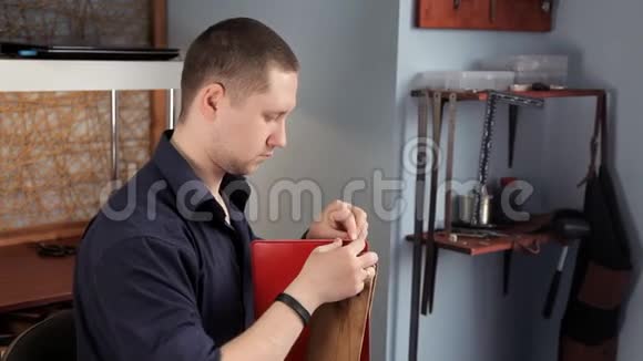 在车间里一个男人正在缝制皮革工件在做钱包视频的预览图