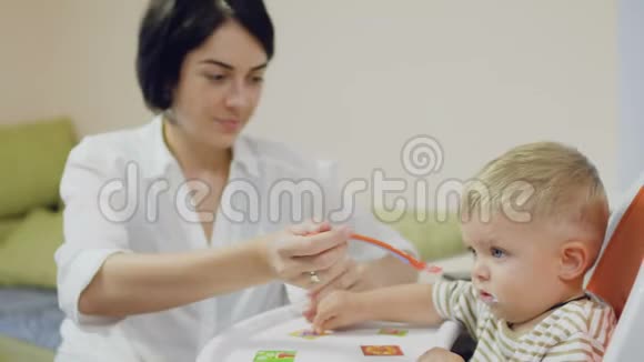 年轻妈妈用酸奶喂小儿子视频的预览图
