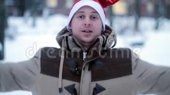 一个戴红帽子的快乐男人落在雪地里视频的预览图