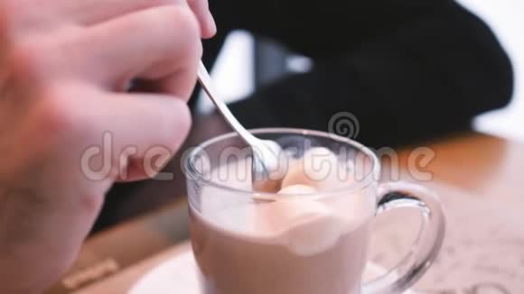 咖啡馆里的热巧克力用棉花糖搅拌热巧克力放入透明的杯子视频的预览图