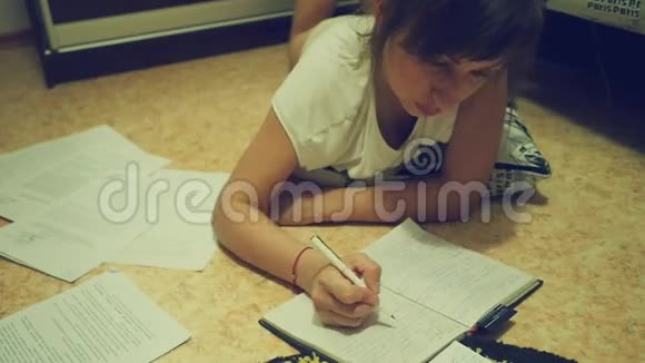 一个疲惫的年轻女子晚上在大学做作业视频的预览图