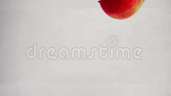 红绿苹果带泡泡落水的慢动作视频孤立的白色背景上的水果视频的预览图