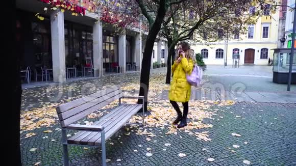 迷人的女人用手机交流在露天漫步在秋天的城市视频的预览图