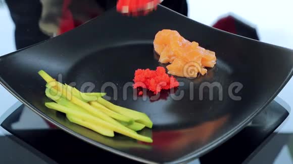 厨师把一盘寿司原料放在桌子上寿司鳄梨和红鱼的配料视频的预览图