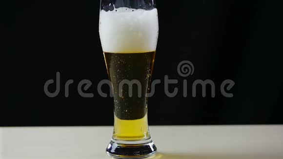 玻璃与啤酒缓慢移动气泡4K框架气泡和泡沫迅速移动在啤酒玻璃泡沫滑下玻璃视频的预览图