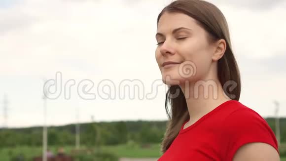 年轻漂亮的女人在公园里散步放松暑假微笑面对背景天空视频的预览图