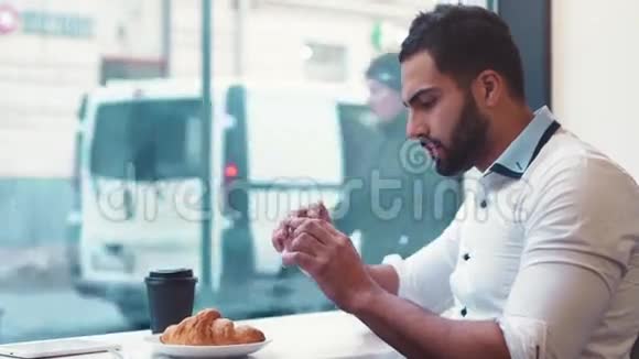 一家咖啡馆的年轻人A拍了几张早餐咖啡和牛角面包的照片然后把它发布在网上现代生活方式视频的预览图