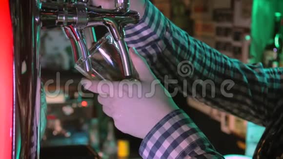 酒保从水龙头里倒啤酒酒保倒一杯完美的啤酒为客户服务视频的预览图