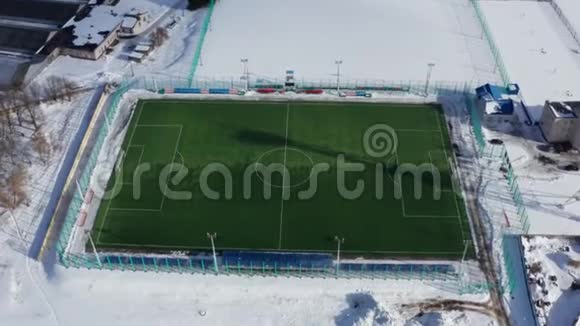业余足球场的空中射击在冬天拍摄一个白色布局的现代足球场4k个镜头视频的预览图