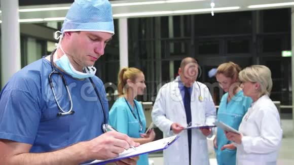 医院走廊的剪贴板上写着微笑的外科医生视频的预览图