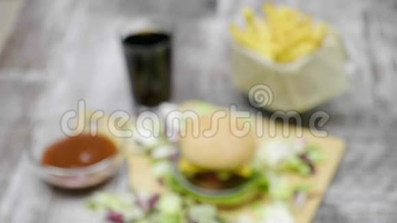 在木制桌子上用薯条做成的美味的家庭汉堡上从焦点放大视频的预览图