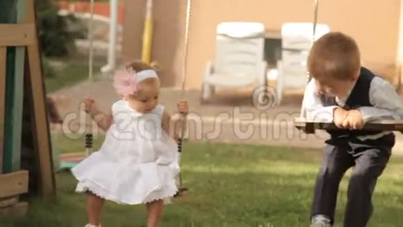 小男孩和小女孩骑在秋千上视频的预览图