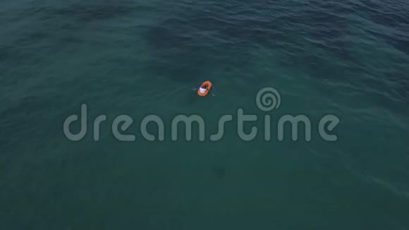 夏天在蓝色海水中划桨的人的空中视频的预览图
