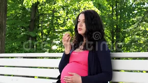 孕妇坐在户外吃苹果视频的预览图