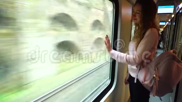 漂亮的女性旅行者离开城市站在大交通窗口附近的火车上视频的预览图