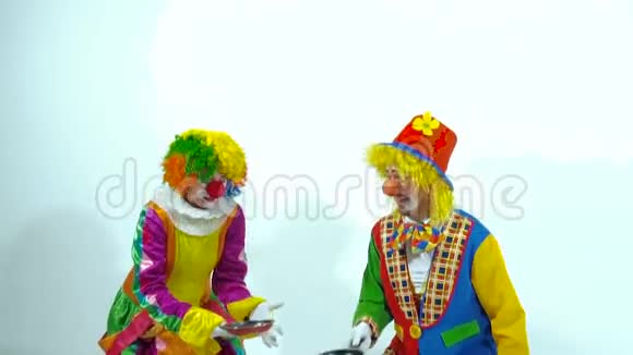 两个滑稽小丑玩平底锅和假蛋糕的肖像视频的预览图