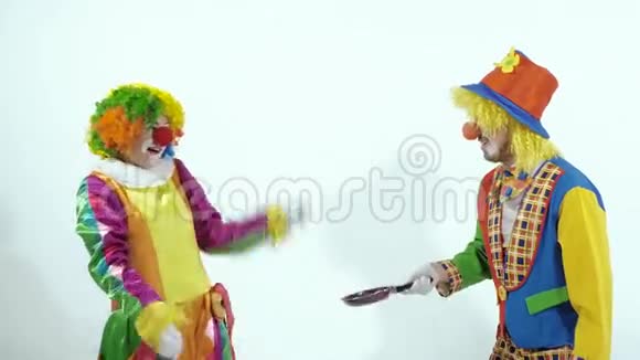 一对滑稽马戏团小丑用煎锅假装功夫拳手的肖像视频的预览图