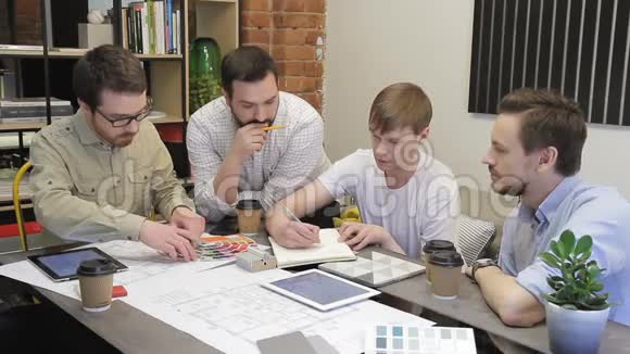 年轻的员工在公司的办公室里坐在桌子旁工作视频的预览图
