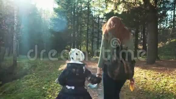 幸福的母女正沿着森林路走着母女走在秋林中吐出来视频的预览图