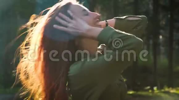 秋天时髦的红发女孩站在森林或公园里视频的预览图