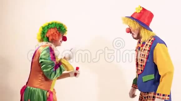 快乐的年轻小丑淋浴喷肥皂泡在另一个马戏团小丑身上视频的预览图
