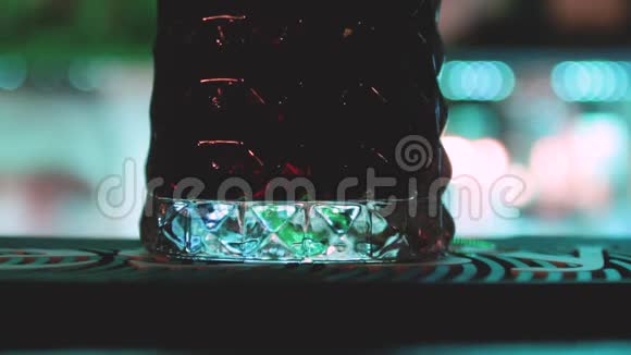 靠近酒吧柜台的彩色灯光背景与一杯饮料和酒保做他的工作视频的预览图
