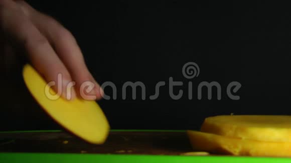 双手在黑色背景上切割芒果视频的预览图