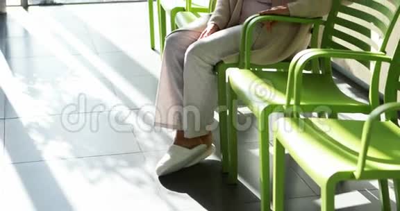 体贴的高级妇女坐在大厅的椅子上视频的预览图