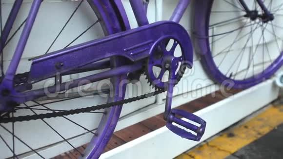 白色墙上的紫色自行车视频的预览图
