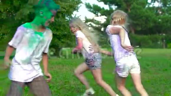 孩子们在草地上跑来跑去互相涂圣粉他们喜欢这个过程玩得很开心视频的预览图