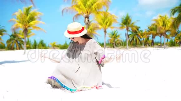 带棕榈树的热带海滩上的年轻美女视频的预览图