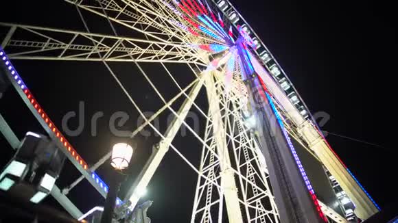 在游乐园度过一个快乐的夜晚五颜六色的被照亮的巨大摩天轮旋转着视频的预览图