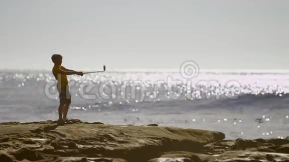 小男孩正在海滩上拍照视频的预览图