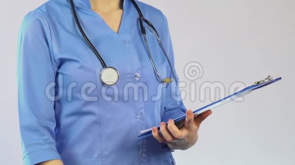 女性治疗师查看病人登记表并书写诊断视频的预览图