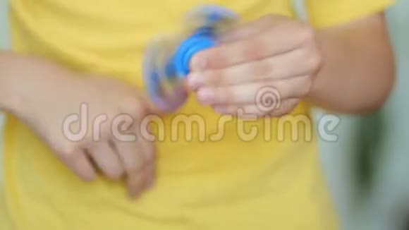 一个男孩手里拿着一个受欢迎的玩具坐立不安的旋转器减压抗压力和放松坐立不安为疲惫的人旋转视频的预览图