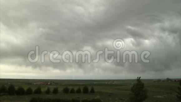 巨大的灰色风暴云在广阔的绿色土地上视频的预览图