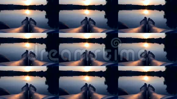 双腿躺在码头附近的湖塘日落黎明日出特写视频的预览图