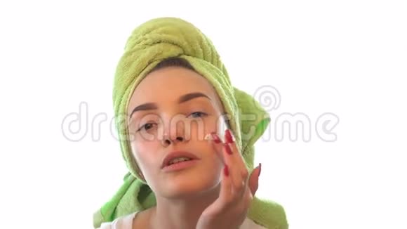 年轻的女孩头上拿着毛巾脸上的奶油轻轻地视频的预览图