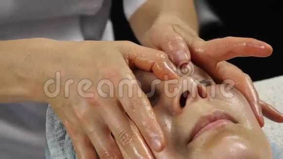 女性医生为客户做抗衰按摩女人在SpaSaton享受塑料面部按摩4K视频的预览图