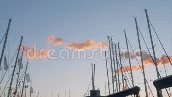 在马略卡日落时小粉彩云和游艇桅杆的图片视频的预览图