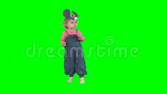可爱的小女孩戴着老鼠帽吃着绿色的环状甜卷视频的预览图
