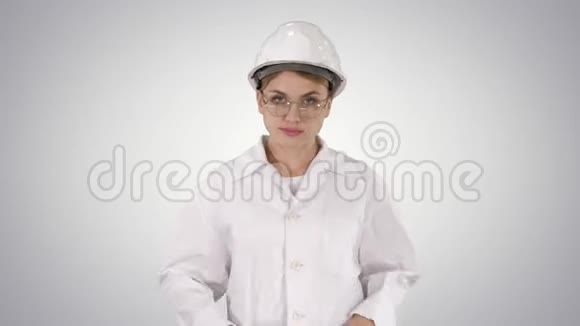 年轻的女工程师戴着安全帽在渐变背景下行走视频的预览图
